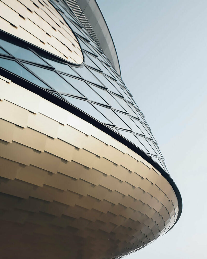 an arrangement of small aluminum triangles facilitates the transition from the planar glass to the double-curved diagrid