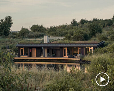 dug into the ground, hello wood's CLT house gently peeks out amid rural flora in hungary