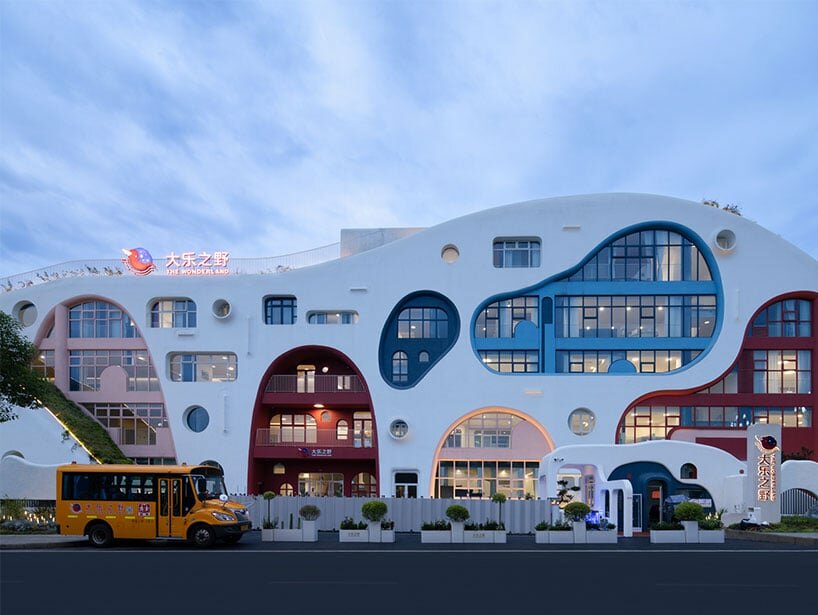 the structure's dramatic undulating slopes emerge from the site