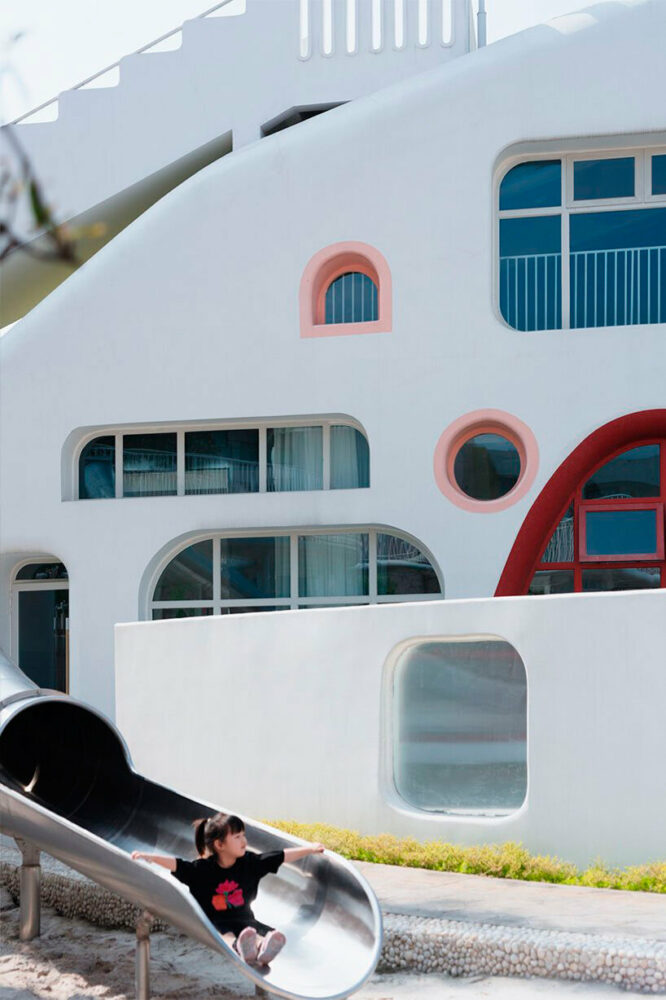 Dalezhiye Kindgergarten’s shape and colors echo the red sandstone mountainscape of the Leshan region