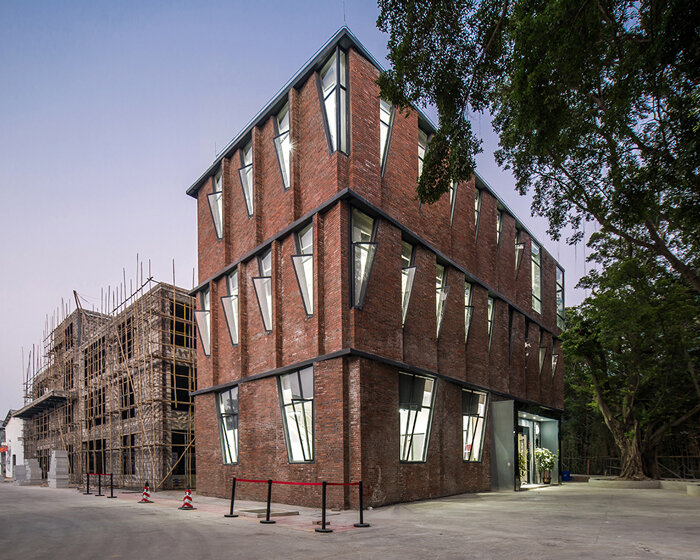 red brick facade with angular windows enfolds multi-use building in china's art district