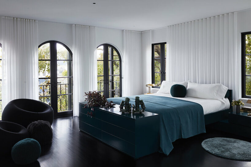 arched windows visible behind full-height, white ripple drapes