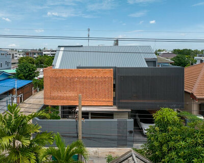 exposed brick wraps residence's facade by bodinchapa architects in bangkok