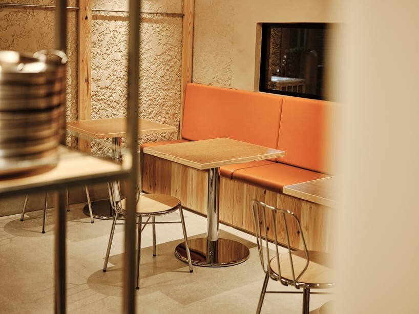 an orange seating bench runs along the wall