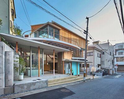 fragmented timber blue box office stands on sloping terrain in japan