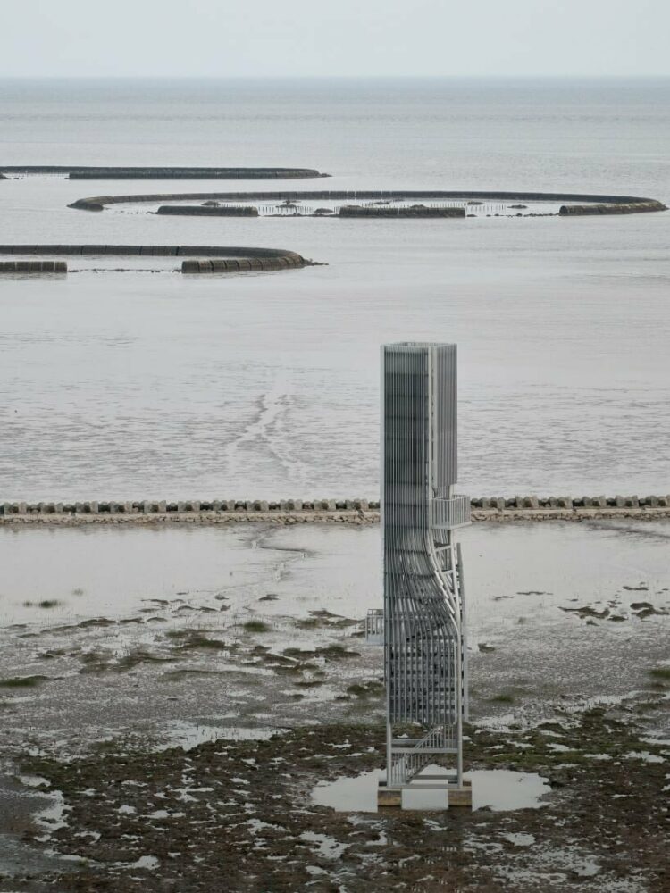 vertical metal louvers envelop the main steel structure, creating an ambiguous sense of scale