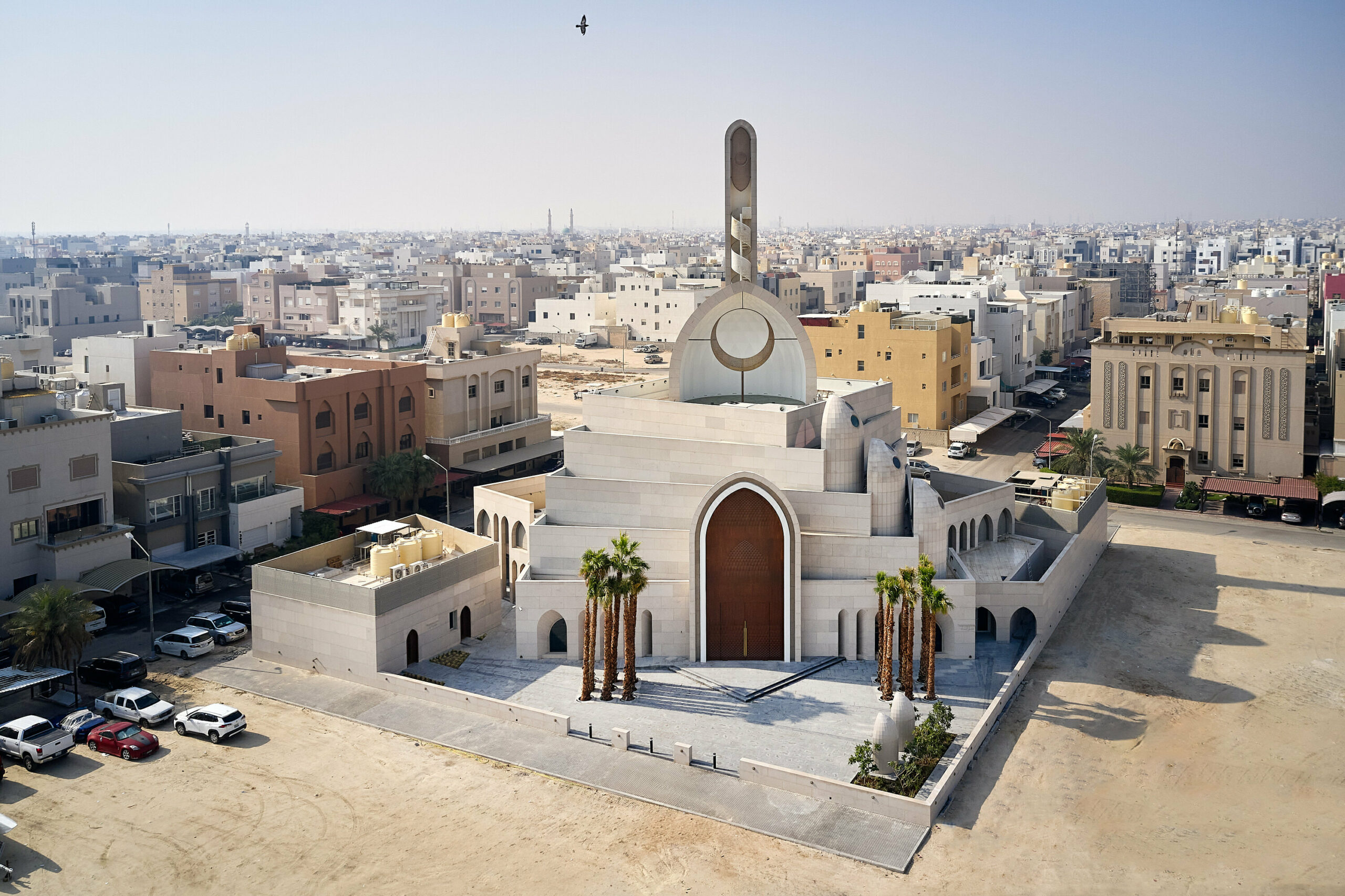 rhythmically stacked, rotating volumes and half domes compose kuwaiti mosque by babnimnim