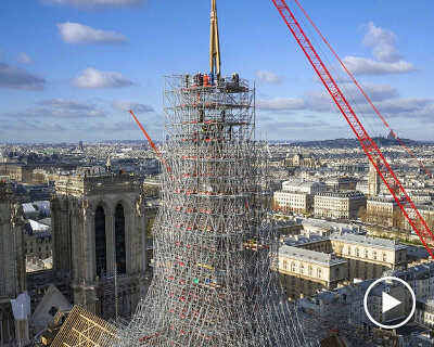 notre-dame’s spire is finally installed, one year before the cathedral’s scheduled opening
