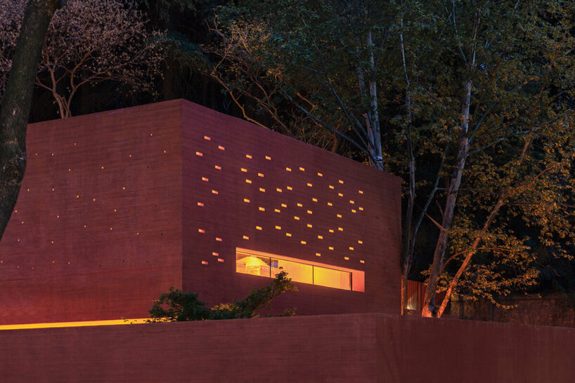 at night, the Red Box emits warm light, casting scattered star-like patterns | image © Arch-Exist