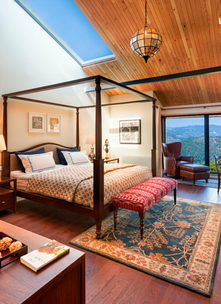 bedrooms feature floor-to-ceiling bay windows and skylights framing expansive views of the landscape