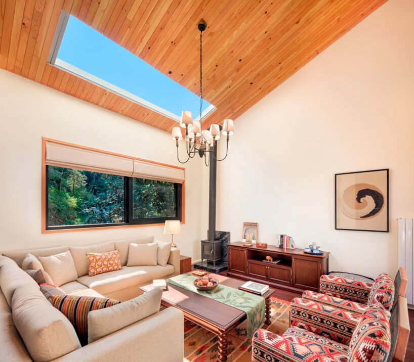 the living spaces merge with the slope overlooking native vegetation