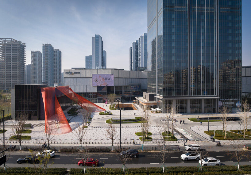 behin ha weaves temporary installation with orange mesh fabric ribbons at hangzhou complex