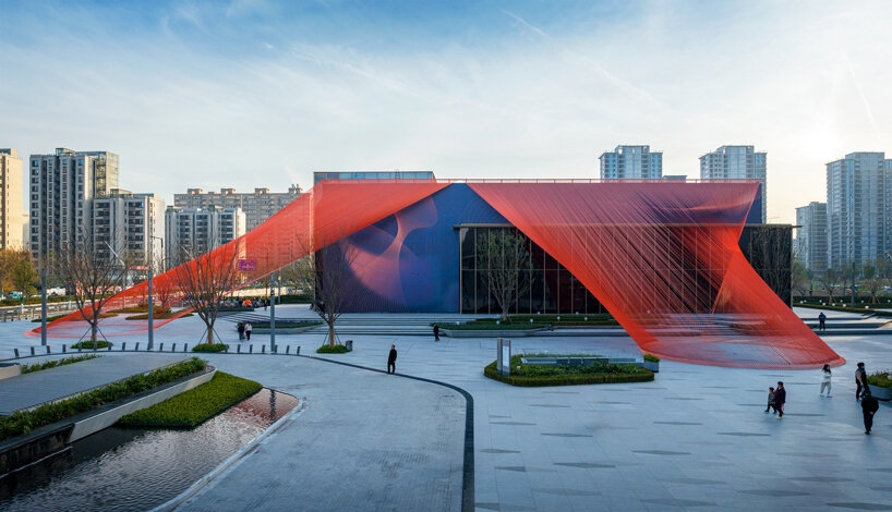 behin ha weaves temporary installation with orange mesh fabric ribbons at hangzhou complex