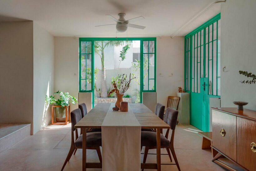 mint green-painted ironwork and tiles in the kitchen establish a more fluid connection to the garden