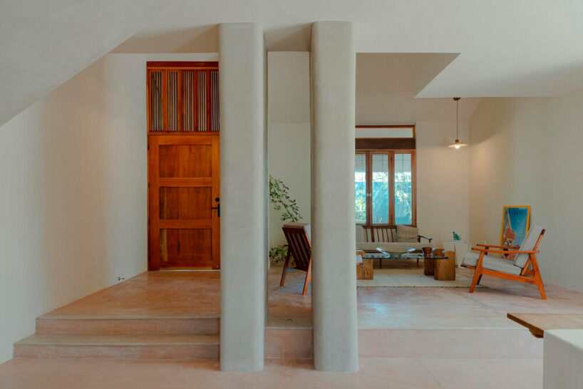 rounded columns in the foyer and addition of warmth and color with cedar doors and pigmented concrete floors