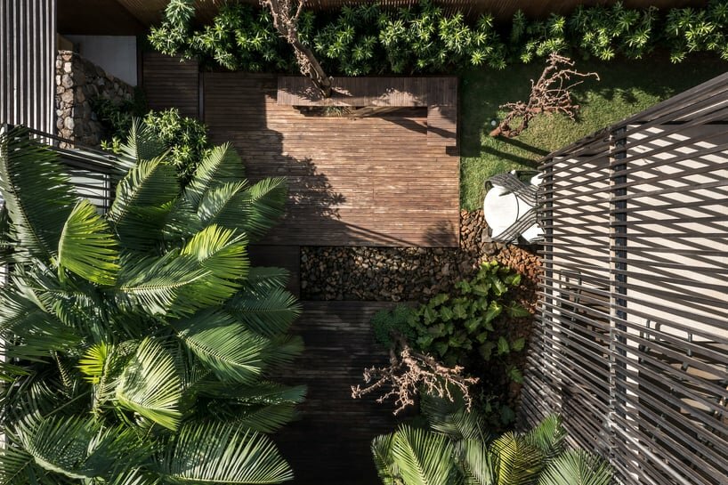 the slatted panels play a crucial role, bridging the interior and exterior, allowing guests to commune with nature