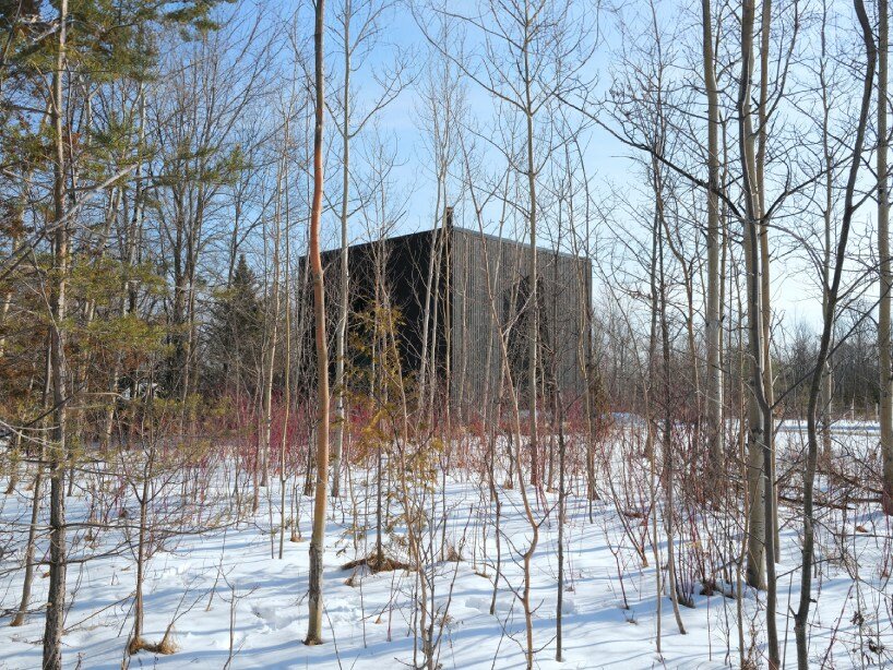 charred wood ski chalet by atelier RZLBD tucks into sloping terrain in rural canada