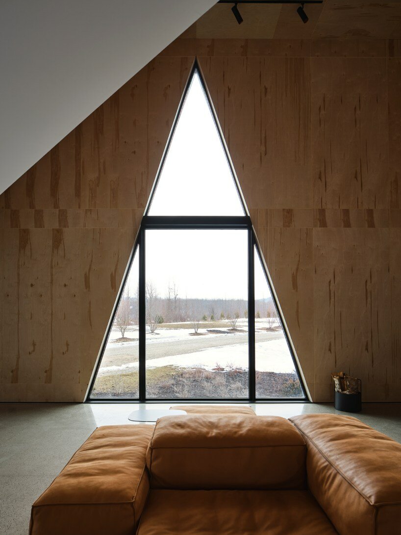 charred wood ski chalet by atelier RZLBD tucks into sloping terrain in rural canada