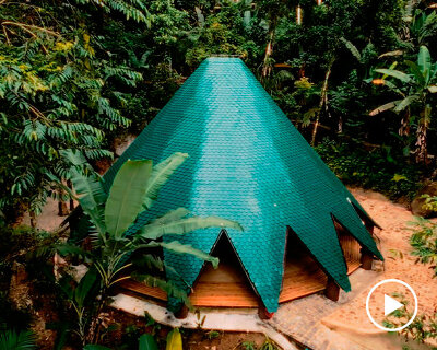 ceramic tiles in blue and green hues cover tapered ayuru forest temple in brazil