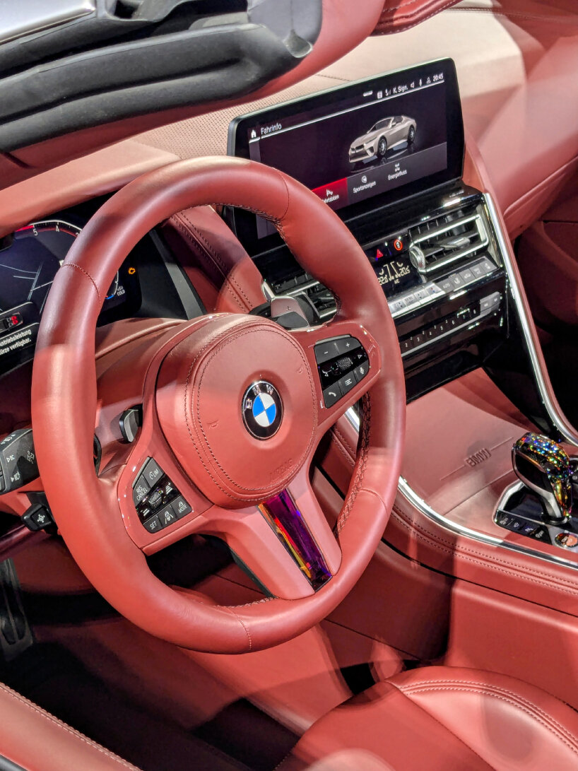 the steering wheel and gear stick have colored crystals | image © designboom