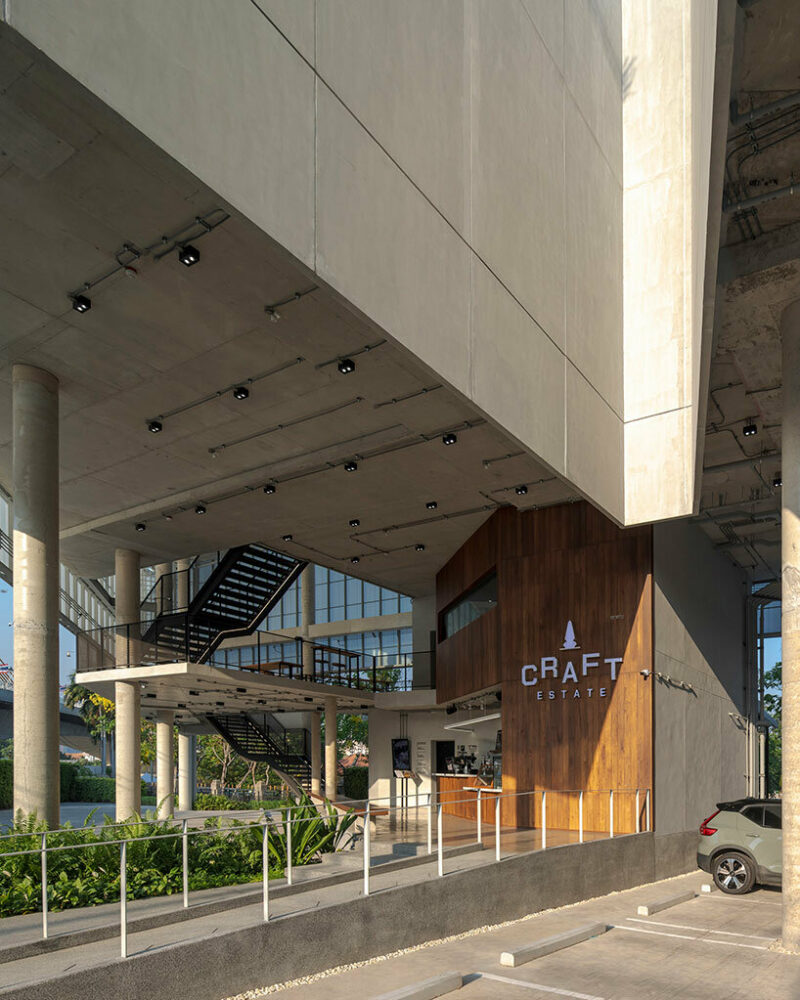 a wooden surface on the facade signifies the entrance to the building