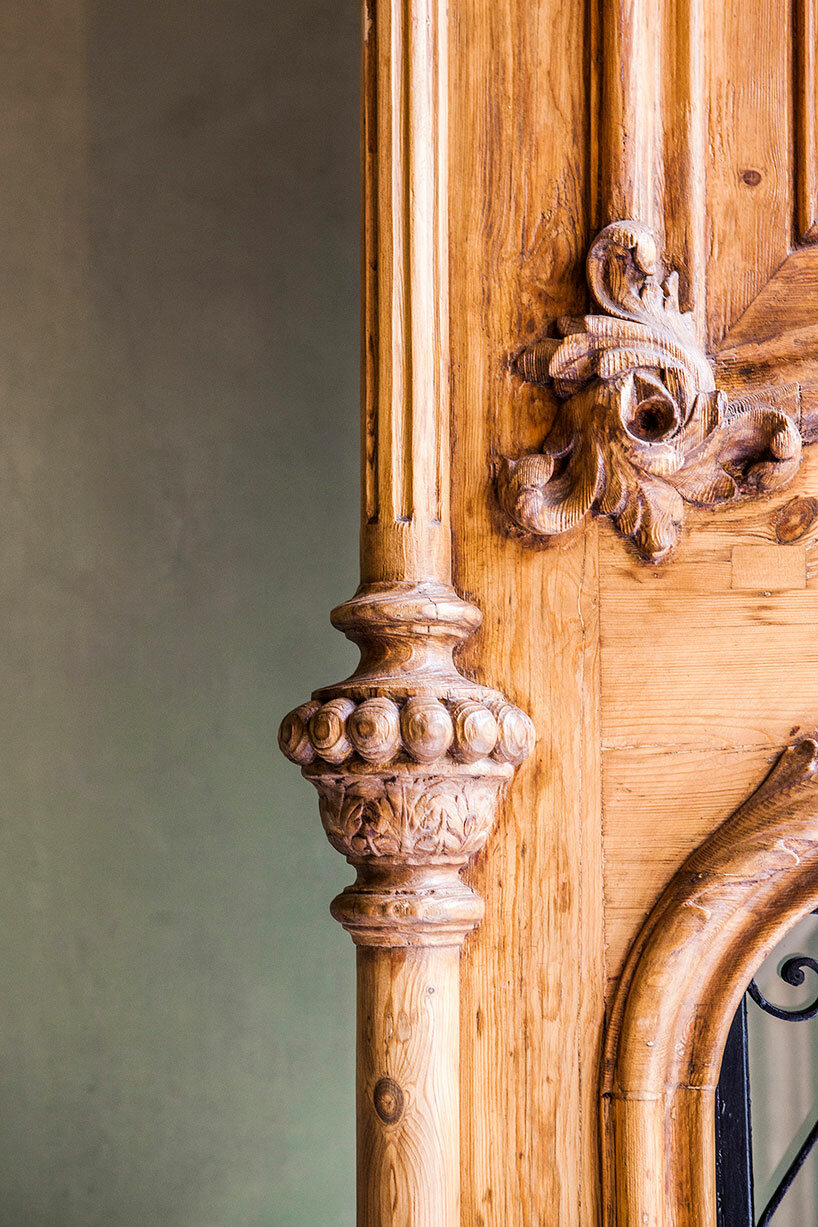 the wooden entrance door of the building is a part of it's ornate facade