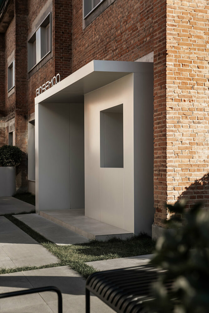 tree shadows adorn the pristine white walls, complementing the weathered mottled red bricks
