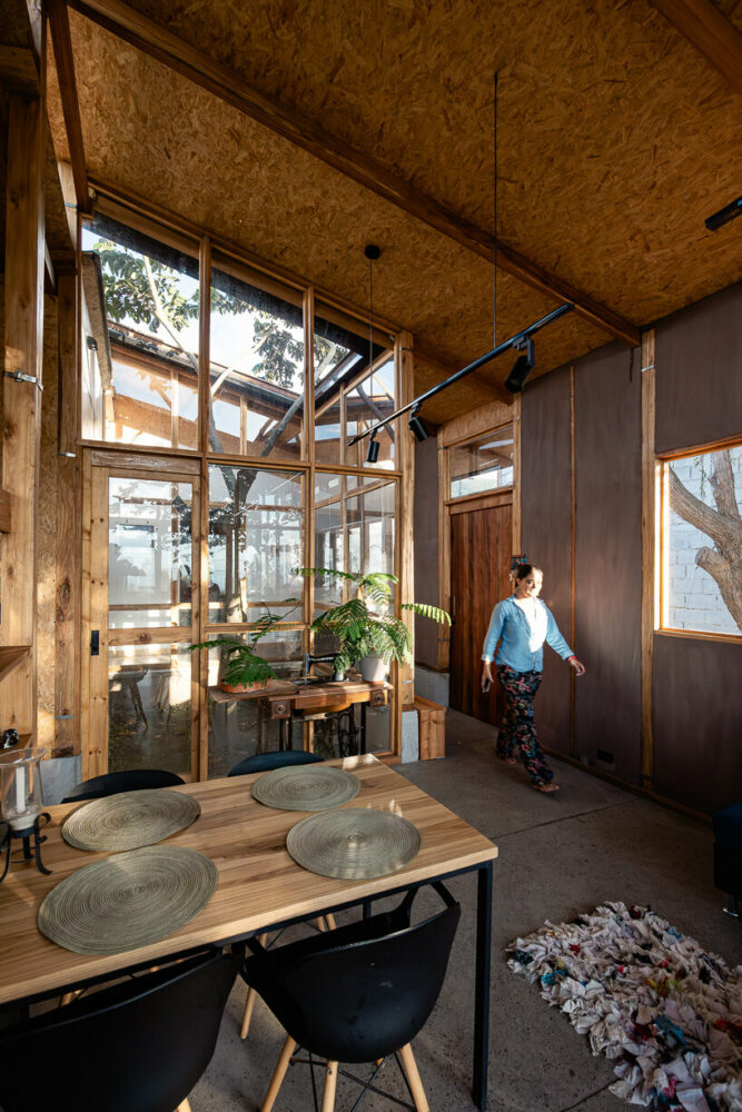earth walls, eucalyptus structures, and wooden finishes contribute to the dwelling's inviting ambiance