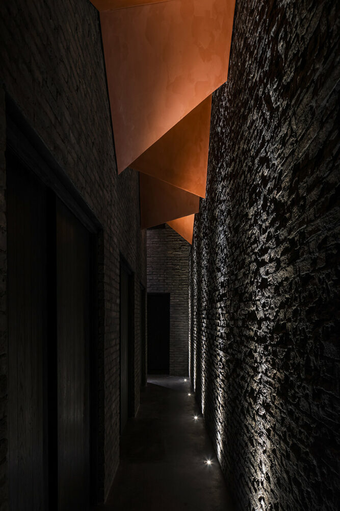 the vermilion ceiling enriches the sequence of the long and narrow hallway 