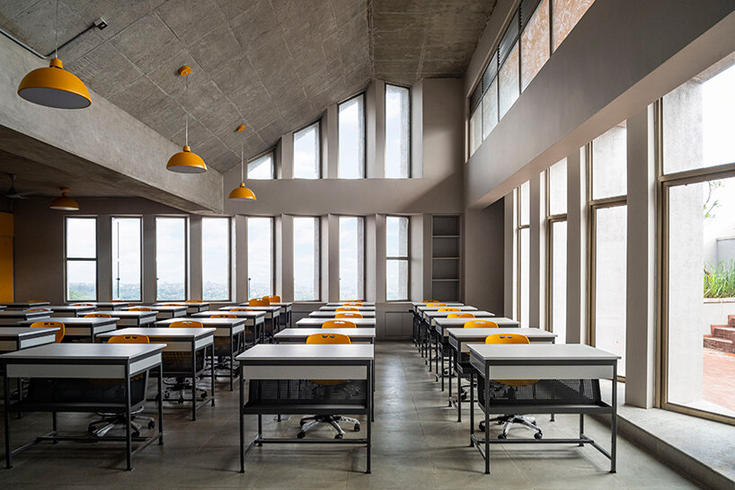 the studio opens up towards the court area, with saw-tooth windows framing valley views while reducing direct sunlight