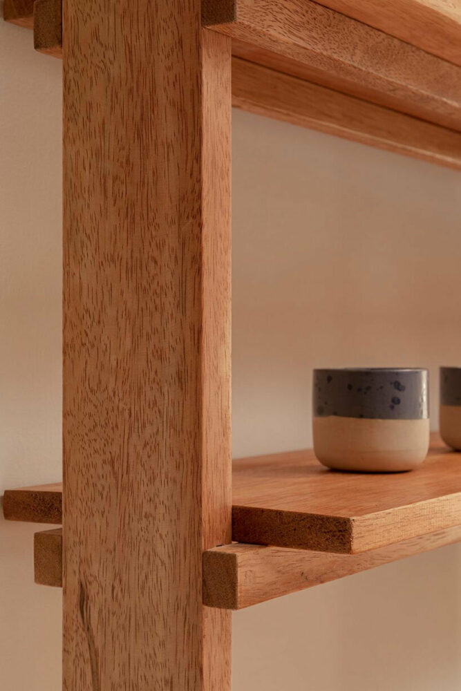 cups are displayed on handmade wooden shelves 