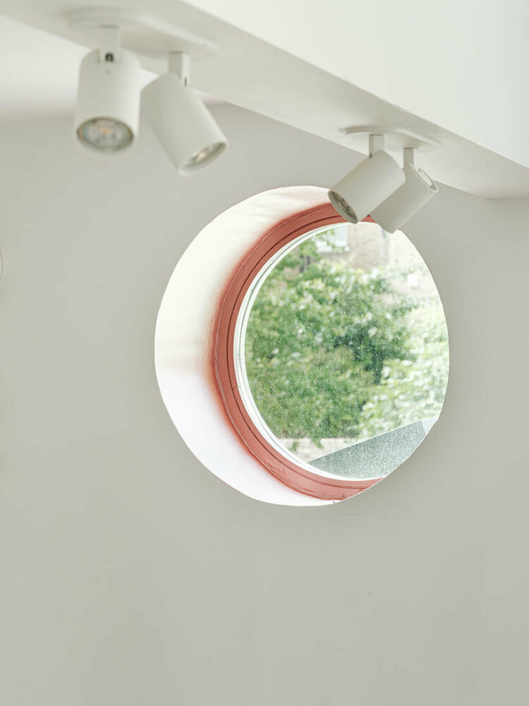 a large glazed skylight with exposed timber rafters illuminates the space