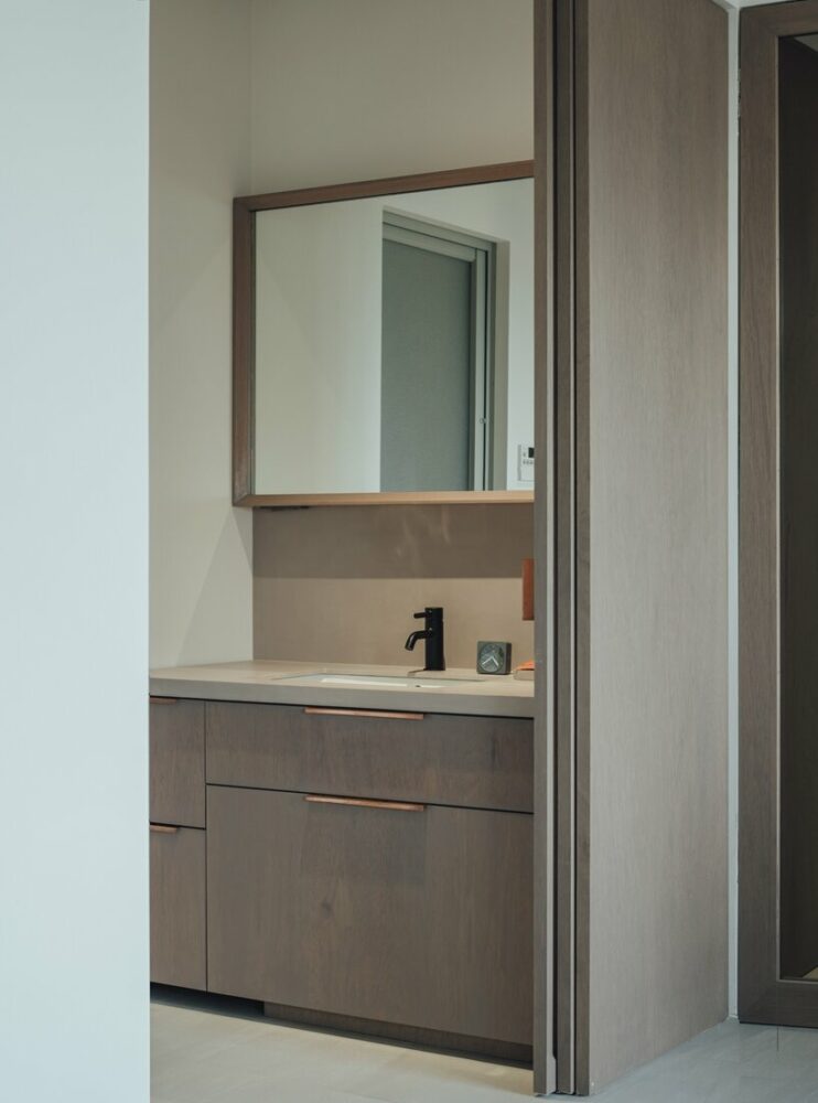 the bathroom features furniture matching the T House aesthetics