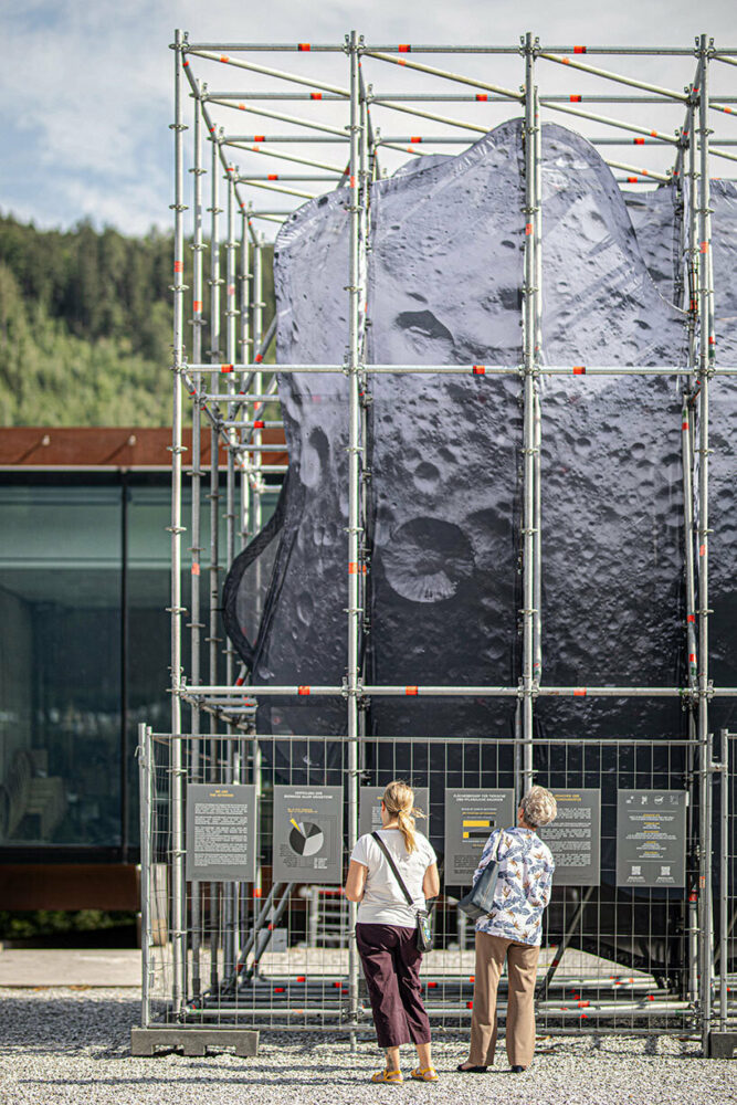spectators looking at 'We Are The Asteroid' installation