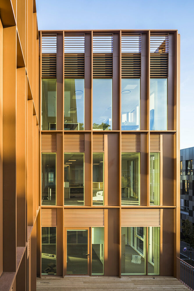 vertical metal slats compose the copper-colored facades of the building