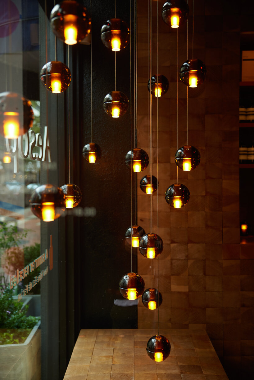 Bocci's glass table lights hanging from the ceiling inside Aesop Gastown in Vancouver