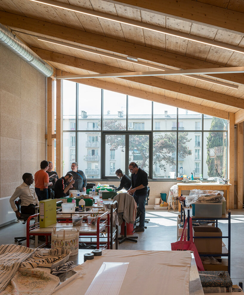 the facility includes creative workshops, a café, logistics areas, and offices, all designed with a focus on accessibility