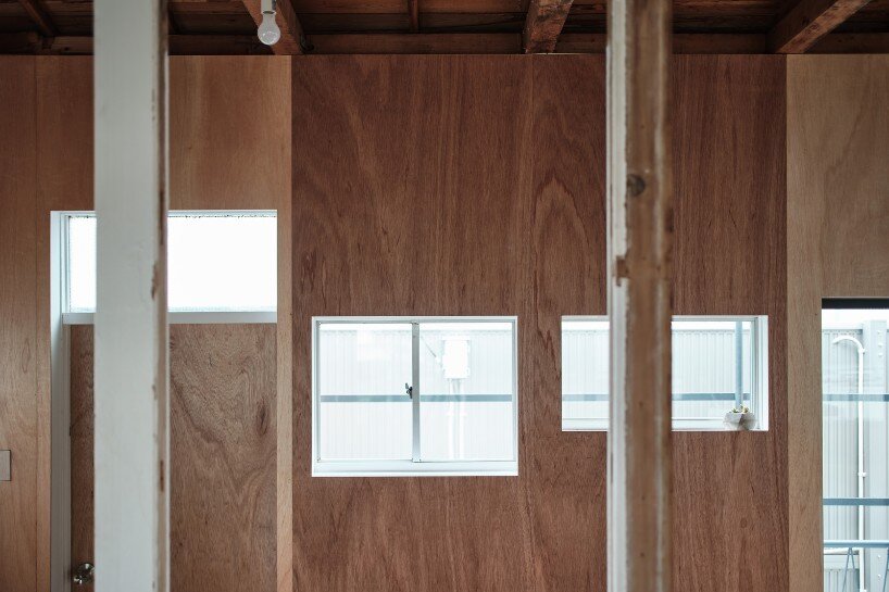 lauan plywood was used on walls and floors, creating a patchwork effect with varied window sizes
