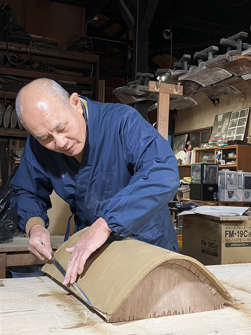 Masahisa Asada refines the surface of the table lamp using a knife in his workshop