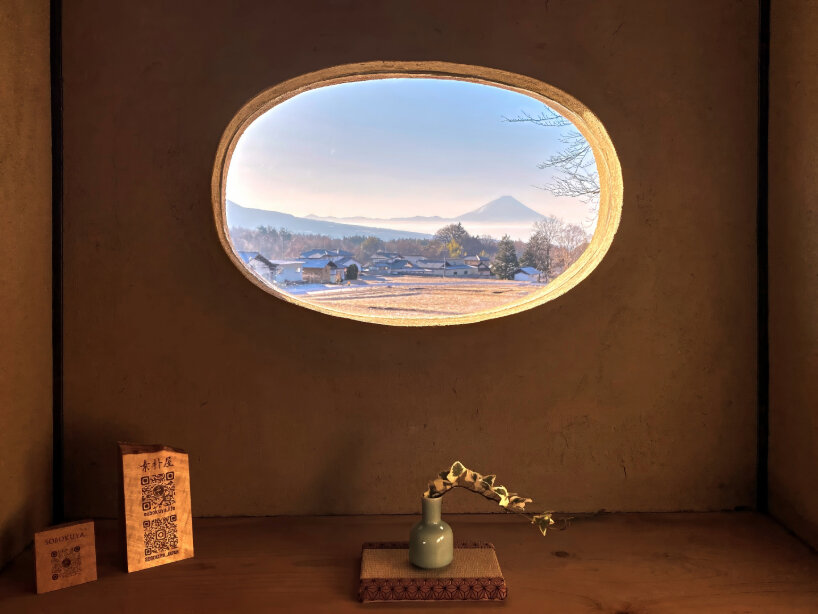 a round window frames Mount Fuji perfectly, creating the illusion of a painting