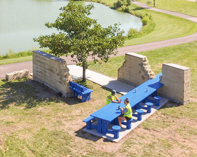 picnic table and bench intersect i/thee's eroded rammed earth walls in iowa park