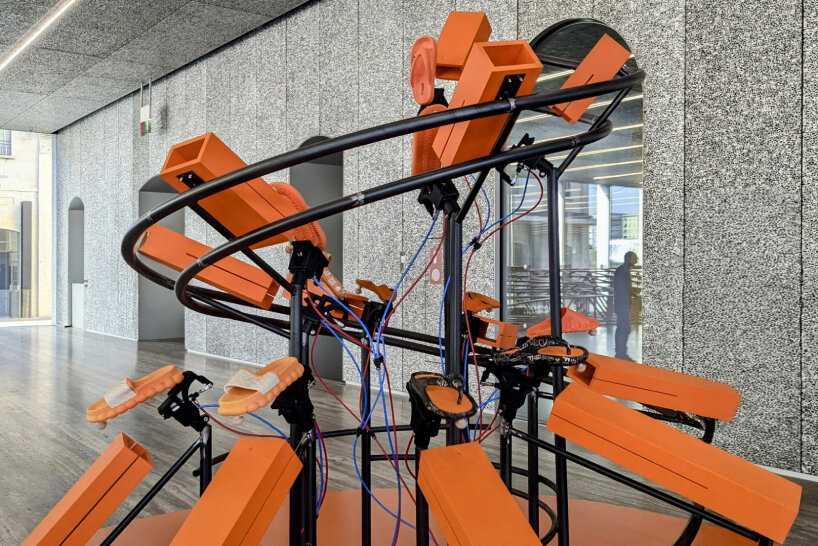 there are two 'spiral' sculptures of mechanized flip-flops and slippers in the exhibition | image © designboom