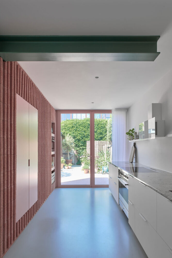 the extension of the pink concrete block creates an interplay of textures in the interior