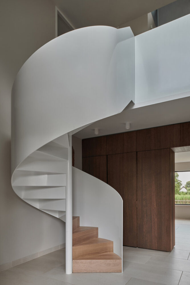 a prominent white spiral staircase leads to the upper-floor bedrooms