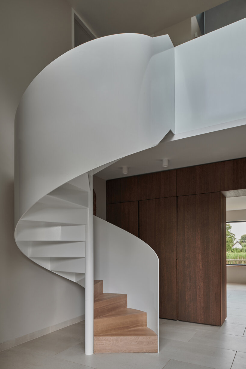 a prominent white spiral staircase leads to the upper-floor bedrooms