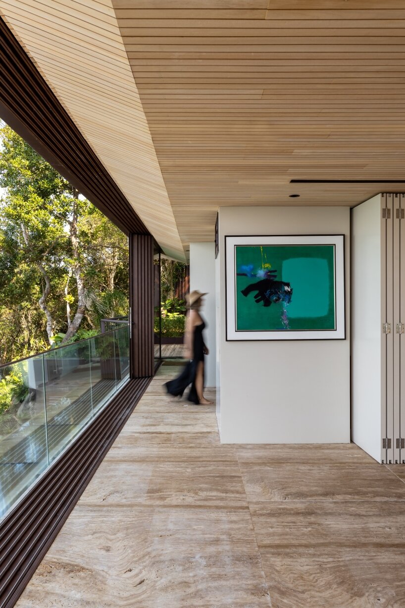 FCstudio's coastal house stacks steel, glass, & stone layers amid são paulo's rugged terrain