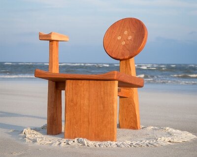 organic contours and asymmetric forms carved from cherry and maple wood define buttonback chair