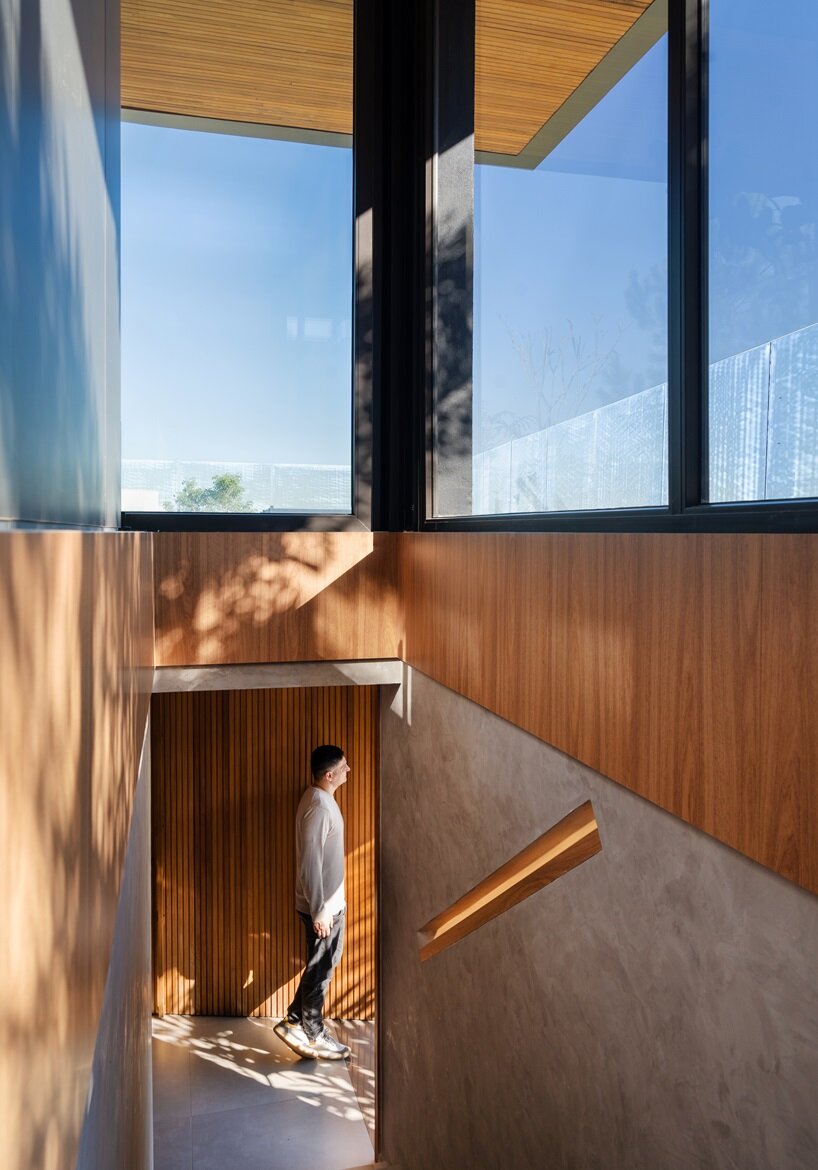 the entrance is via the base volume, half-buried in the lot, including a two-car garage and storage