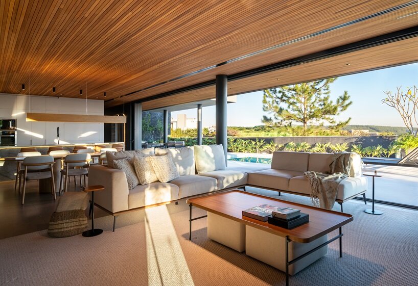 continuous floor and ceiling finishes connect interior and exterior areas, creating a unified space