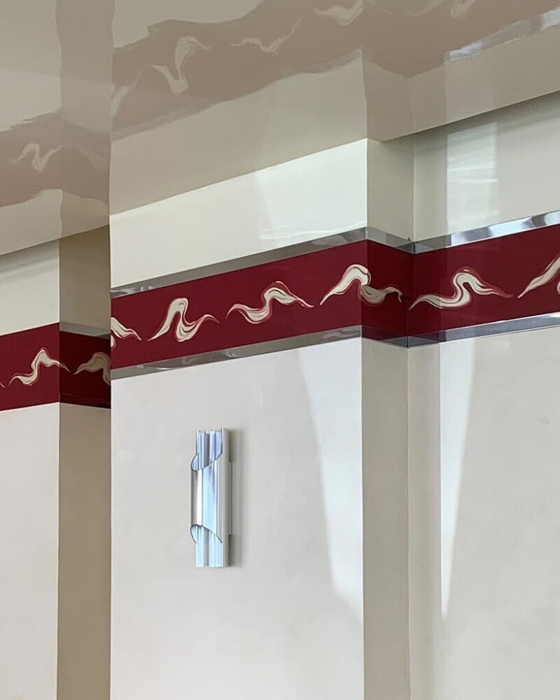 a glossy lacquered ceiling with wave patterns nods to 1950s Italian design